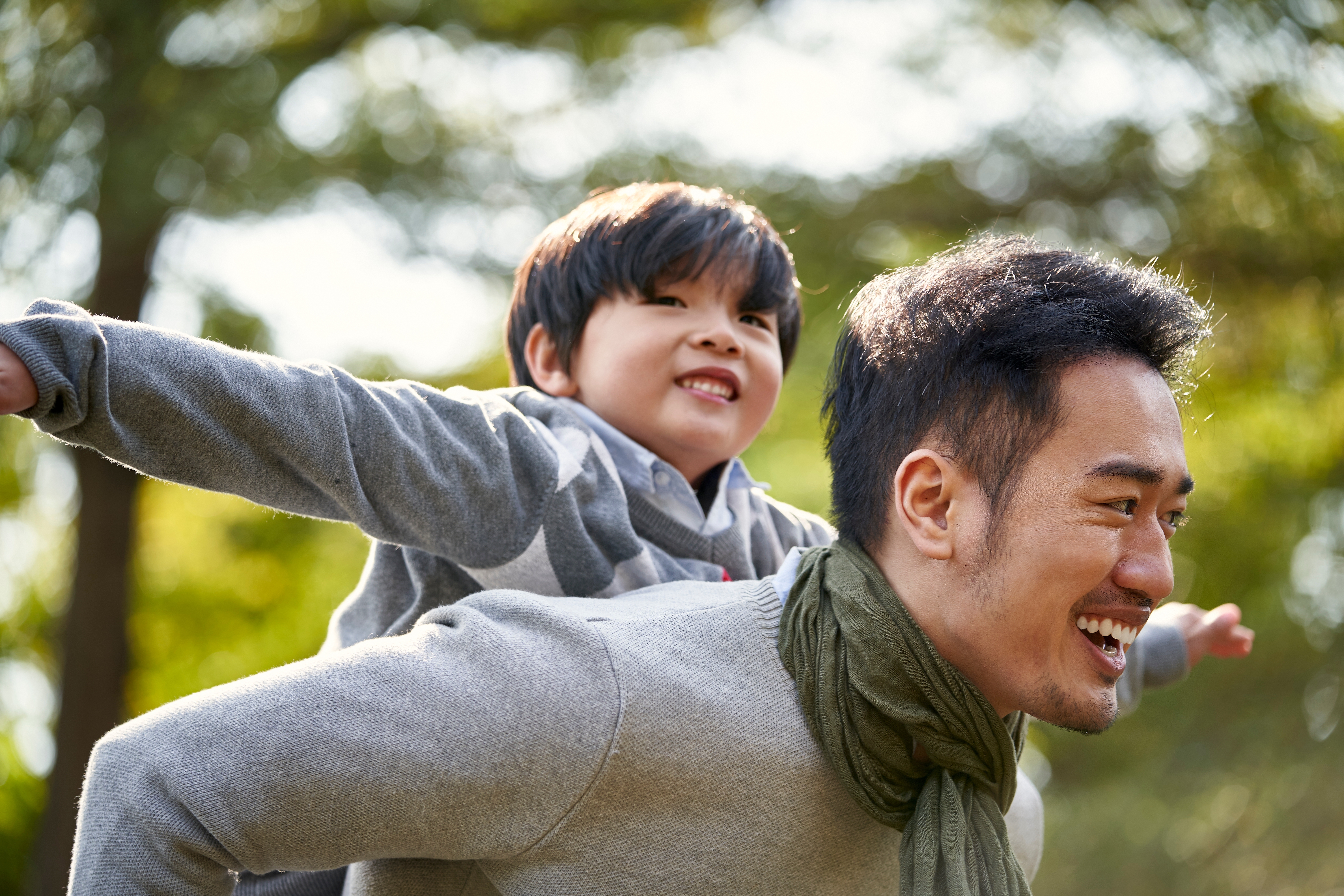 Young,Asian,Father,Carrying,Son,On,Back,Having,Fun,Enjoying